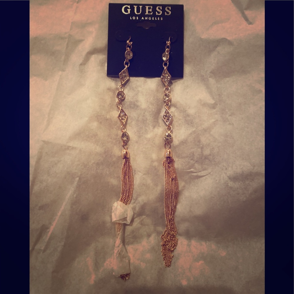 Rose gold colored guess earrings.